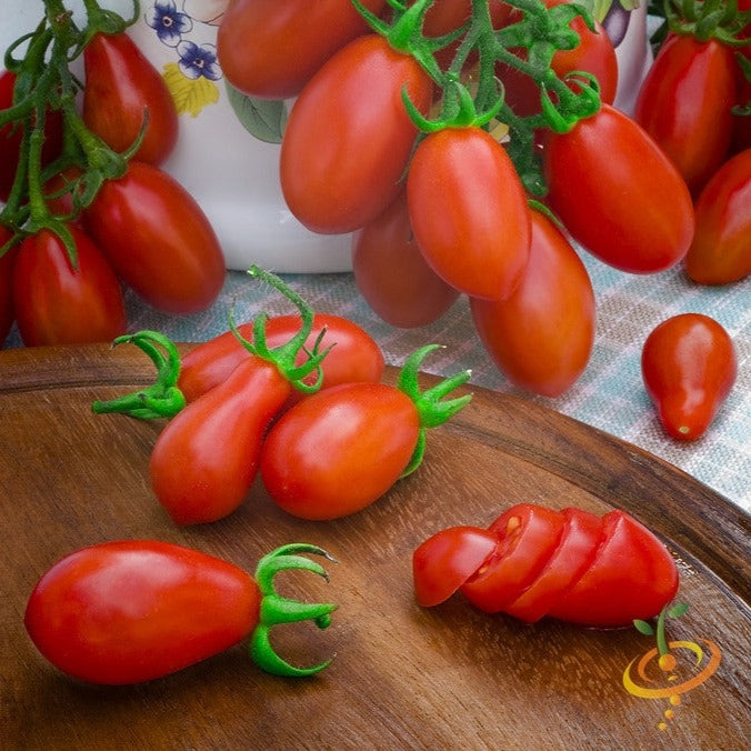 Red Pear Tomato clusters and sliced fruit on wooden board